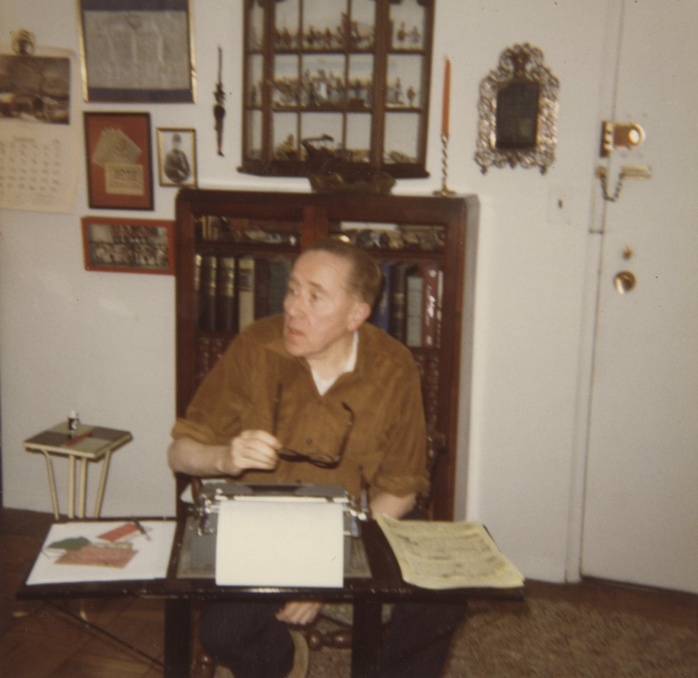 Joe at his typewriter, with his books behind him